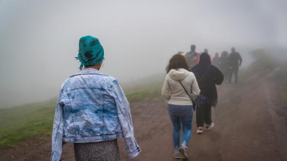 Refugees walk on dirt path