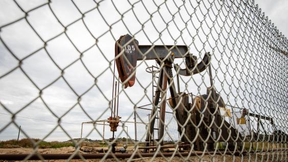 An oil pump behind a fence.