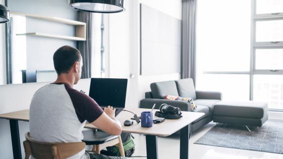 A person doing remote work on their laptop from their house.
