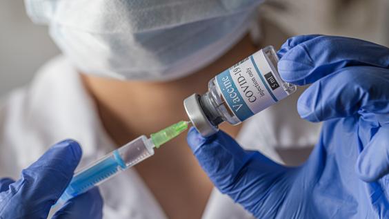 A medical worker fills a syringe with the COVID-19 vaccine 