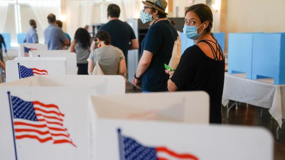 Woman with mask waiting in line to vote in a U.S. election.