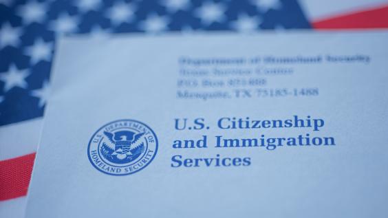 An envelope from the U.S. Citizenship and Immigration Services rests on the U.S. flag.