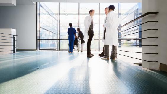 Doctors converse in a corridor.