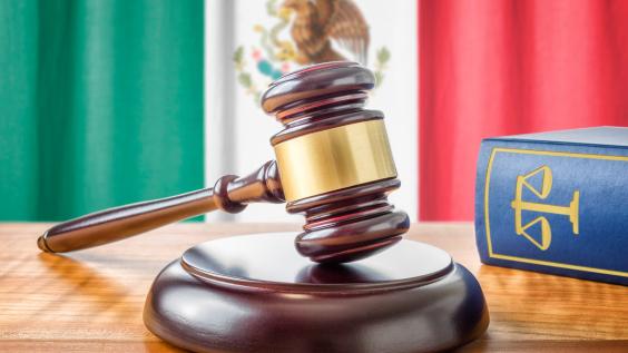 A gavel rests in front of the Mexican flag.