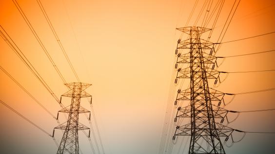 Transmission towers against a sunset.