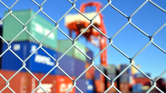 Trade containers behind a fence.