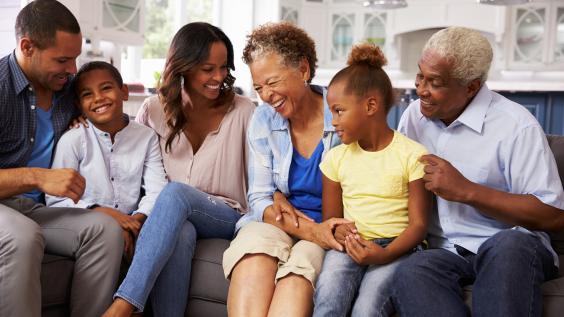 An African American family laughs together.