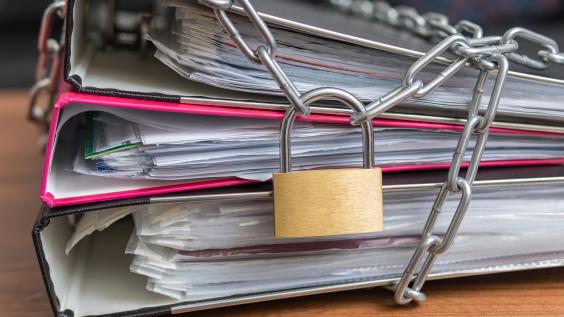 A lock and chains tie three binders together.