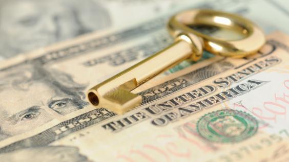 A key lies on top of money.