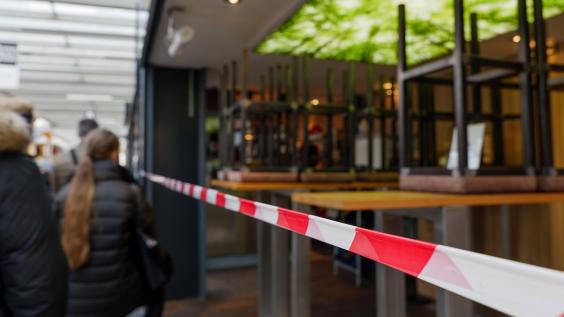 People walk past a closed business.