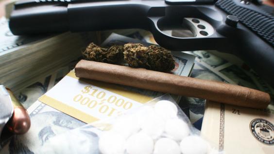 Drugs and a gun with money in a pile