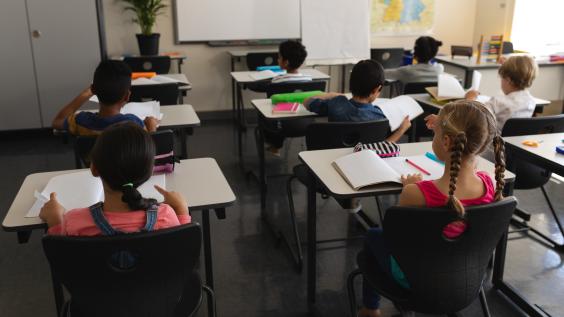 Children sit at desks in school
