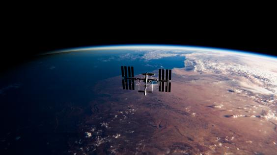 The International Space Station (ISS) orbits the Earth at sunrise