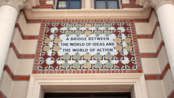 Tile mosaic over an entrance to Baker Hall that reads "A Bridge Between the World of Ideas and the World of Action"