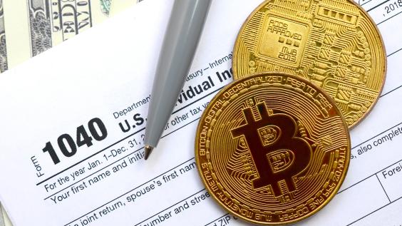 Bitcoins lie on an income tax form.
