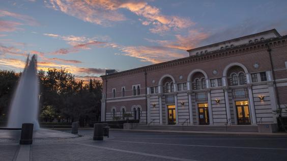 The front of Baker Hall, from across the plaza, with fountain in frame