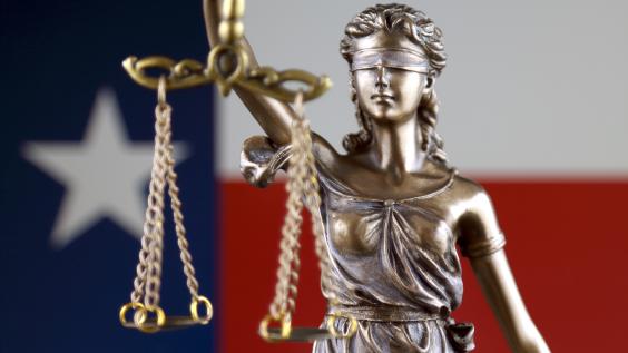 Blind scales of justice with texas flag in background