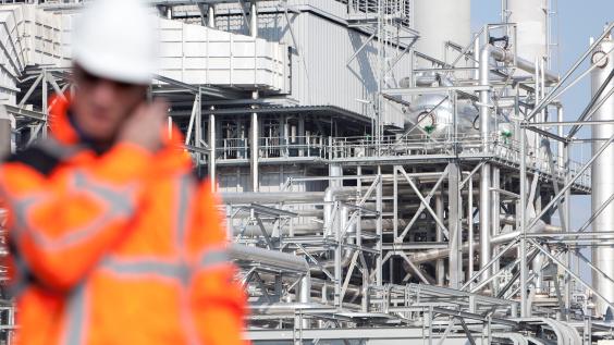 Inspector with refinery facility in background