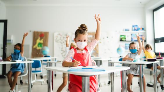 Young students wear COVID masks in the classroom