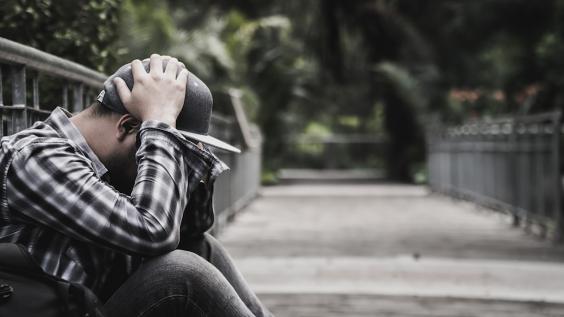 Anxious man with head in hands