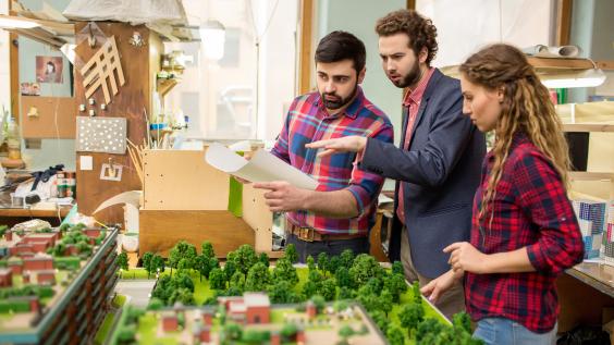 Landscape designers having discussion about city layout model 