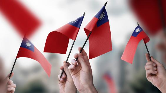  A group of people holding small flags of the Taiwan in their hands