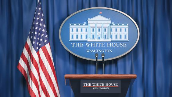 Podium speaker tribune with US flags and sign of White House