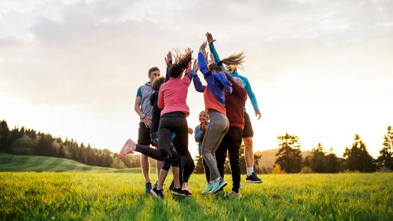 Group of active people jumping after doing exercise in nature. 