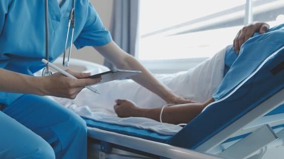 Physician holds patient's hand while encouraging and providing medical advice.
