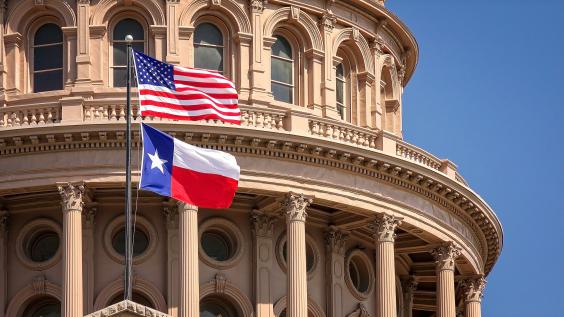 American and Texas state flags and Capitol building