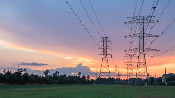 Group silhouette of transmission towers at dusk