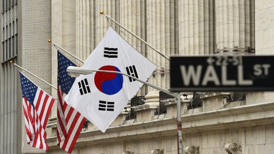 The South Korean flag (R) flies with US flags outside the New York Stock Exchange before South Korea's Ambassador to the US, Ahn Ho-Young rang the opening bell at the NYSE May 13, 2014 in New York.