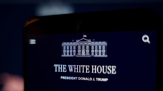 A smartphone screen displays the White House website and the official White House logo.