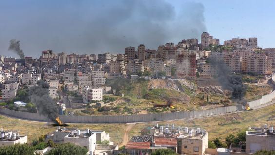 Israel and Palestine divided by wall with smoke and fire pisgat zeev and anata refugees camp, Jerusalem Israel-Aerial view