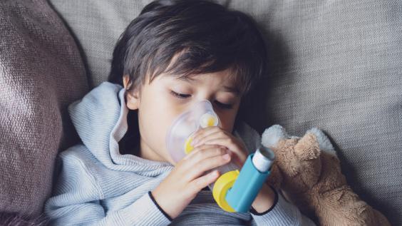 child using asthma inhaler