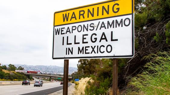Road sign near U.S.-Mexico border that says "Warning: Weapons/ammo illegal in Mexico"