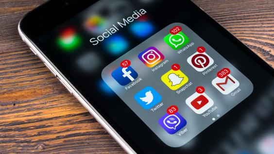 Apple iPhone 7 on wooden table with icons of social media