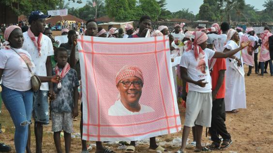 Supporters of President Umaro Sissoco Embalo show a red keffiyeh bearing his image during a political rally in Bissau