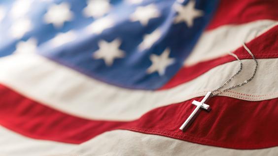 Christian cross necklace on American flag.