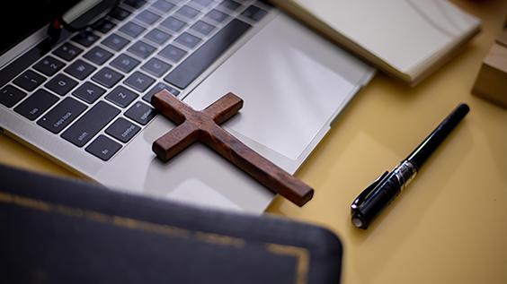  Cross on bible with headset and laptop in online study bible concept.