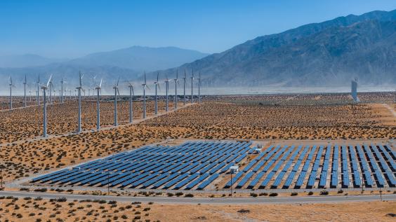 solar panels and wind turbines in desert landscape