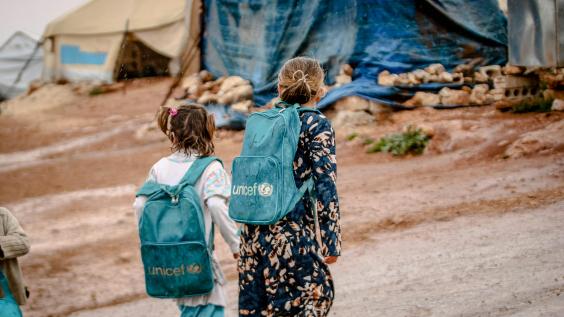 Refugee girls wearing UNICEF backpacks