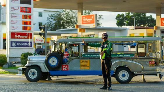 Traffic officer manages jeepney at petrol station