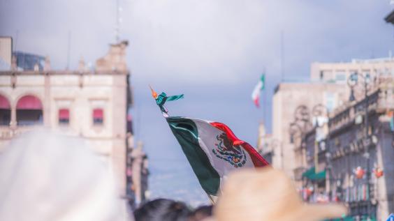 Foto de la bandera de México entre la gente en el centro histórico de Morelia.