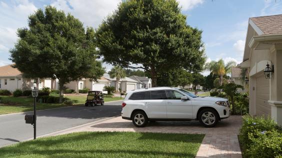 Luxury car parked on the driveway of a house in a Florida residential area reserved for mid aged people, USA 2017