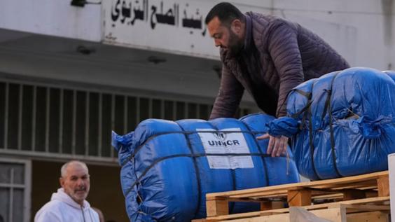  A man unloads humanitarian aid supplied by the U.N. refugee agency UNHCR at a school in Beirut used as a shelter for people displaced by Israeli airstrikes.