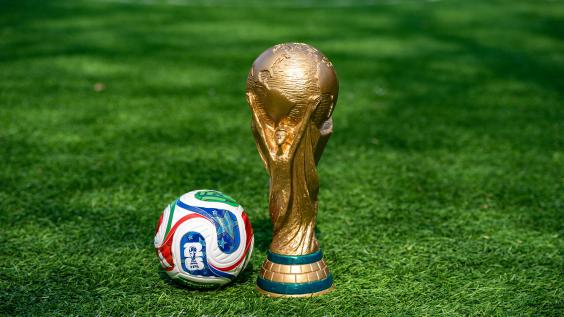 May 7, 2026, United States. The trophy of the 2026 FIFA World Cup and the official Adidas Trionda ball on the green lawn of the stadium. 