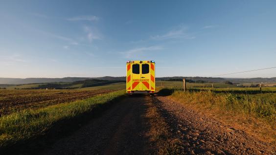 Yellow ambulance on a dirt road: medical transport in rural area