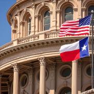 A close-up of the Texas Capitol building and the U.S. and Texas flags.