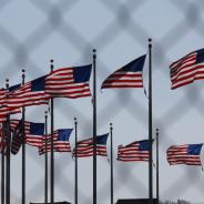 U.S. flags behind a chain-link fence